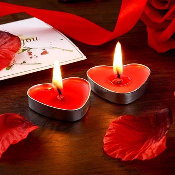Dvě svíčky ve tvaru srdce s romantickou dekorací